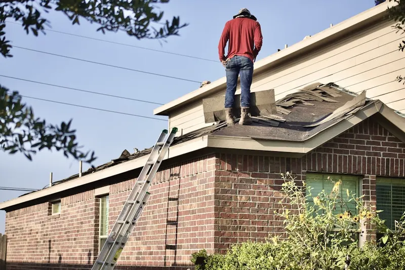 Professional roofer working on a residential roof in Liberal